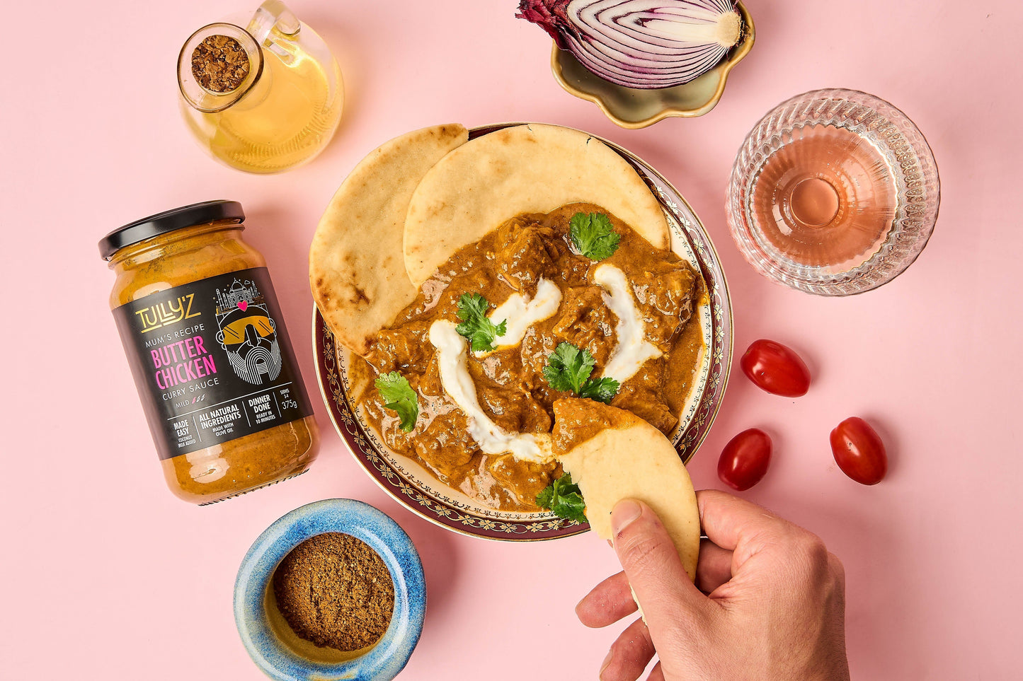 Classic Butter Chicken served with naan and garnished with coriander.